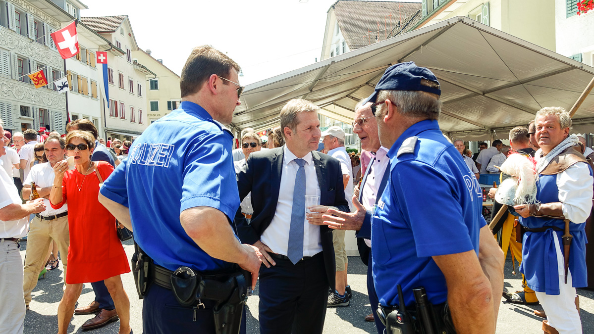 Regierungsrat Marcel Schwerzmann im Gespräch mit Gästen und anwesenden Polizisten.